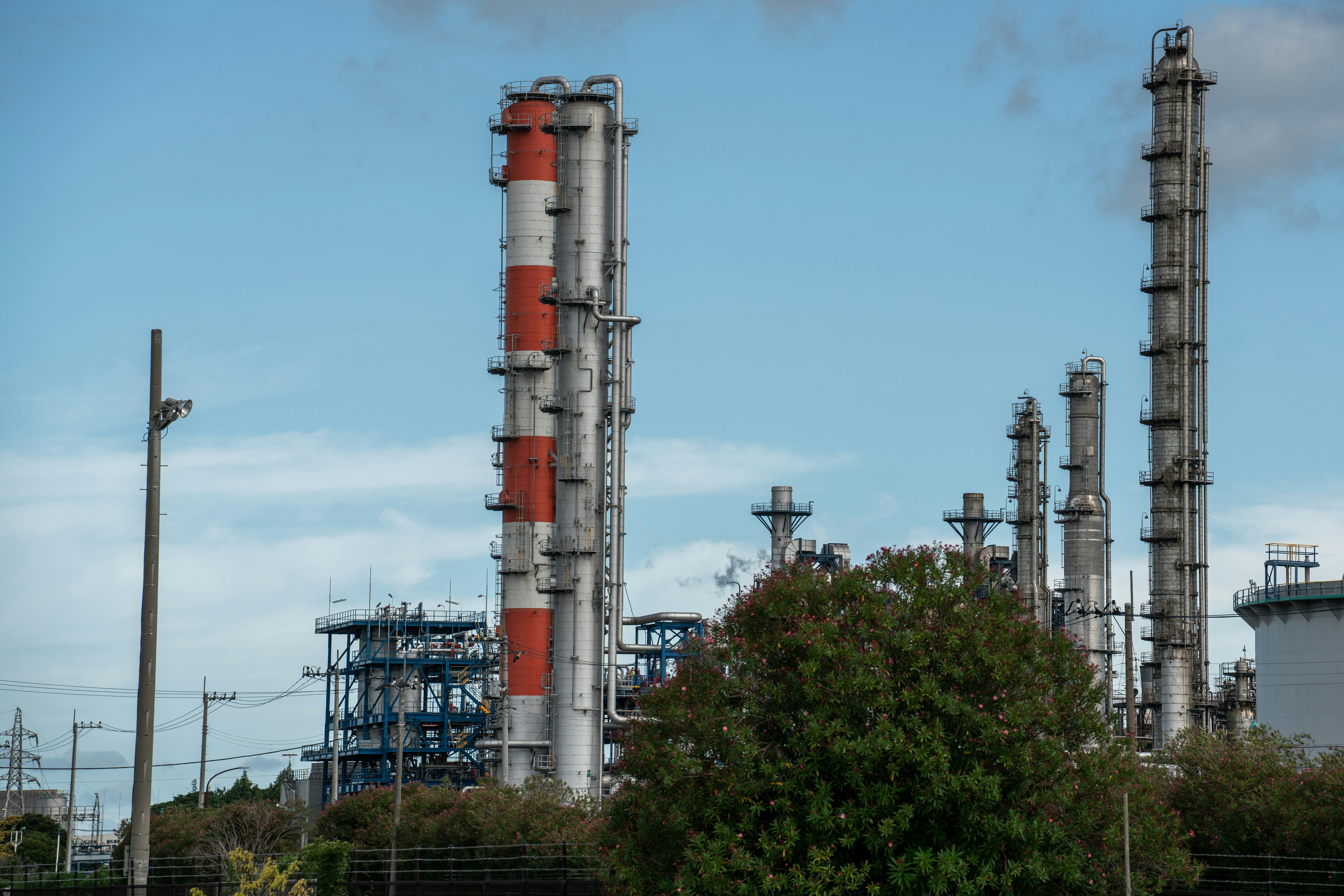 Tours d'une raffinerie pétrolière se détachant sur un ciel bleu, photo d'illustration